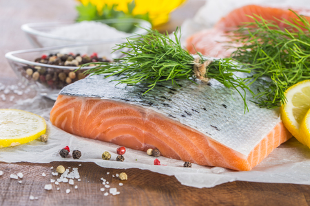 Raw salmon fillet with dill lemon olive oil salt and pepper.の写真素材