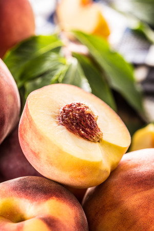 A group a ripe peaches on wooden table.の写真素材