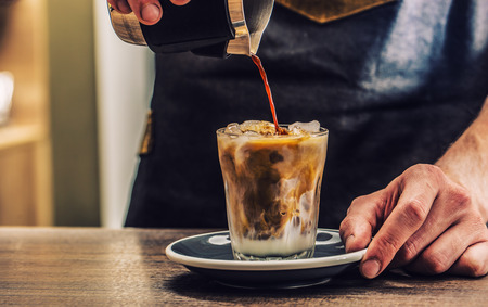 Close-up a barista making fres ice coffee on barcounter.