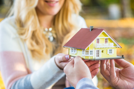 Young loving couple holding small model house.の写真素材