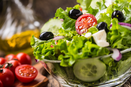Vegetables lettuce salad with tomatoes onion cheese and olives.の写真素材