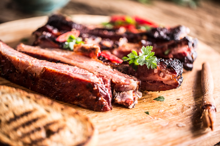 Tasty barbecue grilled pork ribs with chili pepers and parsley herbs.の写真素材