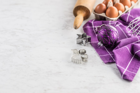 Christmas baking purple gifts decorations eggs and kitchen utensil on marble table.の写真素材