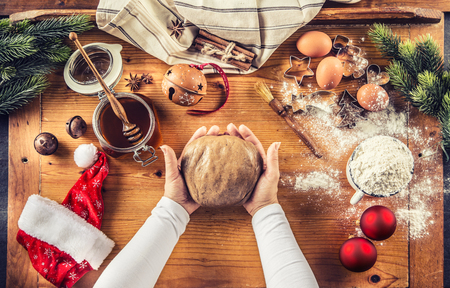 Gingerbread dough and woman hands preparing christmas biscuit cakes.の写真素材