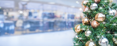 Christmas tree with gold decoration in shopping mall - panoramic blurred banner.の写真素材