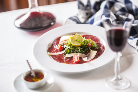 Carpaccio with tomatoes arugula parmesan lemon and red wine.の写真素材