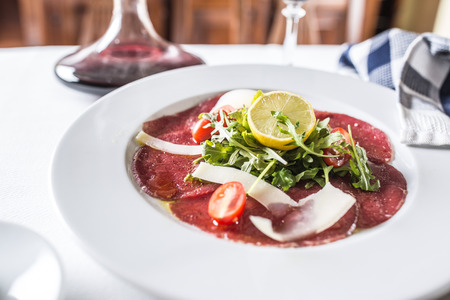 Carpaccio with tomatoes arugula parmesan lemon and red wine.の写真素材