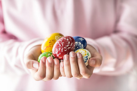 Close-up multicolored easter eggs in the girls hands.の写真素材
