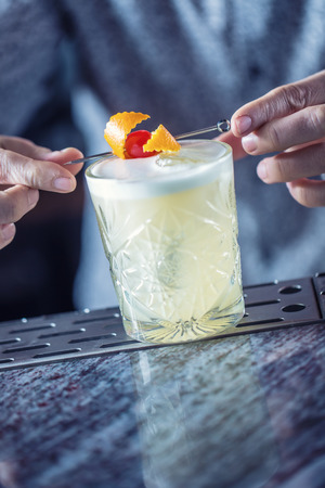 Professional barman making cocktail drink and decorated with fruits.の写真素材