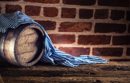 Oktoberfest wooden barrel and blue tablecloth on rustic oak table.の写真素材