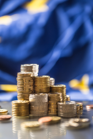 Towers with euro coins and flag of European Union in the background.の写真素材