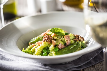 Fusilli pasta with green peas ham walnuts with white wine. italian or mediterranean cuisine.の写真素材