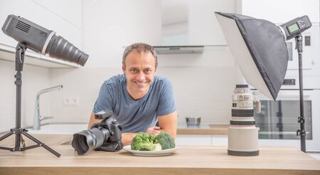 Photographer professional in her studio kitchen with equipment camera flash lights and lenses.の写真素材