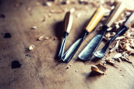 Woodworking vintage tools chisels with wood shawings on retro workbench.の写真素材