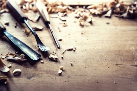 Woodworking vintage tools chisels with wood shawings on retro workbench.の写真素材