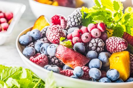 Frozen fruits blueberries blackberry raspberry red currant peach and herbs melissa.