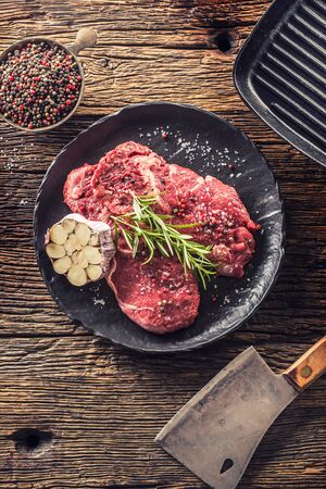 Beef meeat Rib-Eye steak wit rosemary salt and pepper on black plate.の写真素材