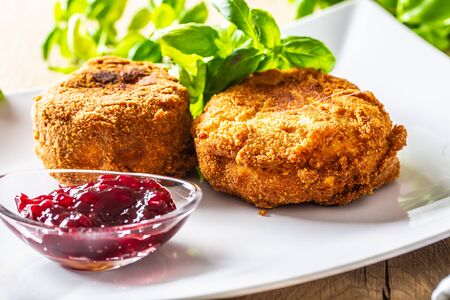 Fried camembert or brie cheese with cranberry jam and basil.の写真素材