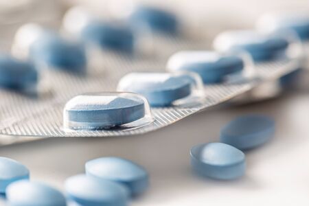 Blue pills loose lying on a white isolated background.