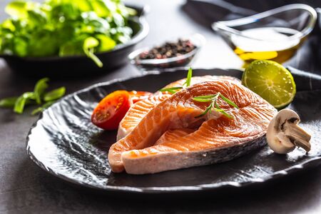 Salmon raw steaks rosemary tomatoes mushroom lime olive oil and spices - Close-up.の写真素材