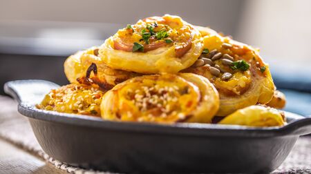 Rolls of puff pastry with ham bacon cheese sesame in dish.の写真素材