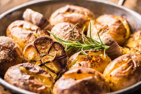 Potatoes roasted with garlic spices and herbs in vintage pan.の写真素材