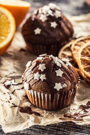 Christmas chocolate delicious muffins sprinkled with topping and white stars.の写真素材