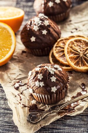 Christmas chocolate delicious muffins sprinkled with topping and white stars.の写真素材