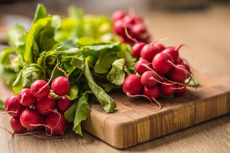 Fresh bundles of radish laid on a kitchen table.