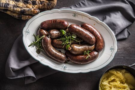 Roasted sausages in pan with rosemary. Traditional european food bratwurst jaternice or jitrnice.