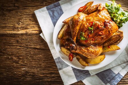 Roasted chicken and american potatoes with chili peppers and herbs - Top of view.の写真素材