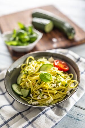 Spaghetti zucchini raw vegan pasta with feta cheese cucumber and basil.の写真素材
