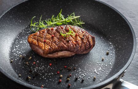 Duck breast roasted in ceramic pan with salt spices and rosemary.の写真素材