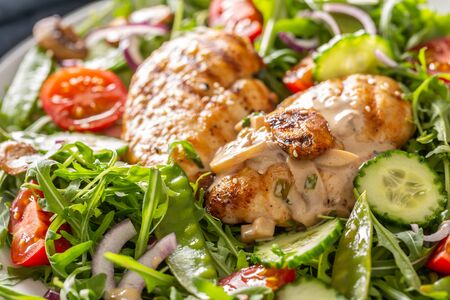 Close up of a healthy fresh salad with grilled chicken breasts and mushrooms on a plate.の写真素材