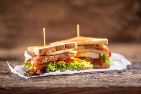 Club sandwich on a rustic table witch chicken, bacon and veg.の写真素材