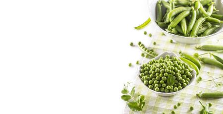 Green raw peas and pods in pocelain bow isolated on white background.の写真素材