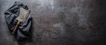 Old meat butcher on dark concrete board - top of view.