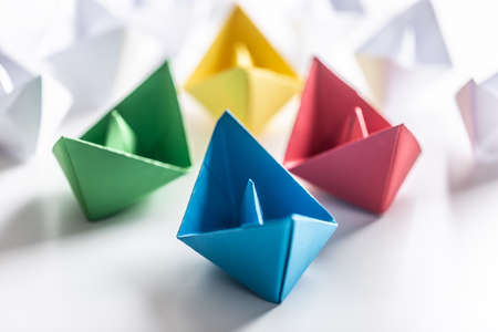 Multi colored paper boats. Concept of leadership boats for teamwork group or success.