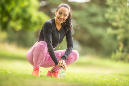 Close up portrait of smiling sporty attractive young woman outdoors.