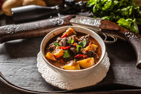 Deer stew in a bowl hunting weapon as a decoration.の写真素材