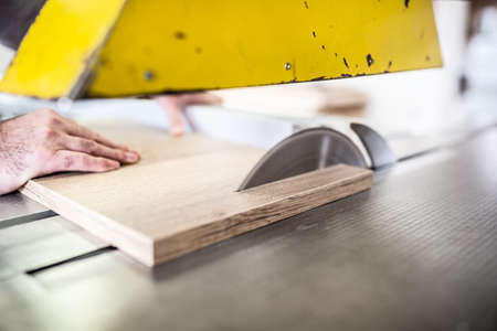 Work in a carpentry workshop by a circular saw.