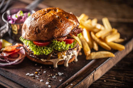 Classic beef burger with cheese cheddar bacon wegetable and french fries.の写真素材