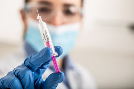 A SARS Cov-2 vaccine in syringe ready to apply vaccination into a patient by a medical staff.の写真素材