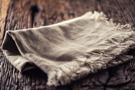 Flax or jute rustical rag folded on dark wooden table.の写真素材