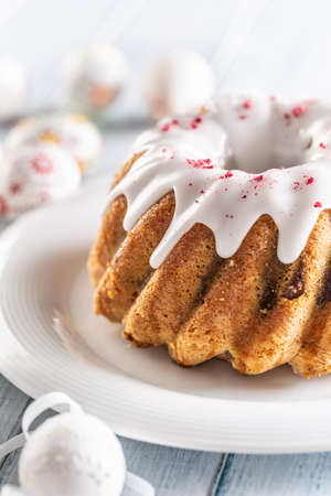 Festive easter marble cake with icing sugar with hand-decorated eggs.