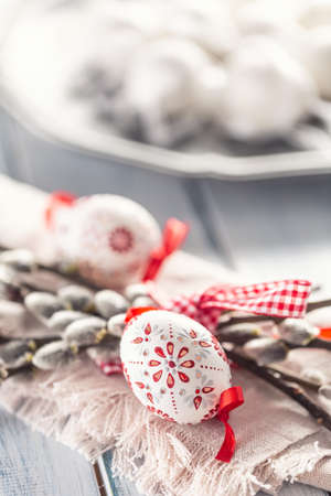 Handmade easter eggs with willow catkins on a linen napkin.