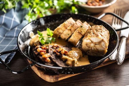 Svieckova food with dumplings, sauce and beef served in a dark plate. Typical Czech food.の写真素材