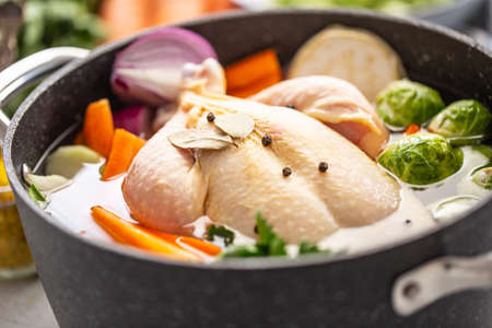 Chicken ready to cook broth with fresh root vegetables and spices.の写真素材