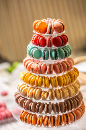 Colorful macaroons on a tower tray in a pastry shop.