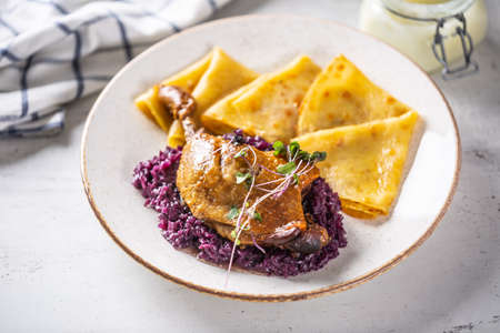 Portion of duck leg with red cabbage and potato pancakes, a traditional autumn dish in Eastern Europe.の写真素材